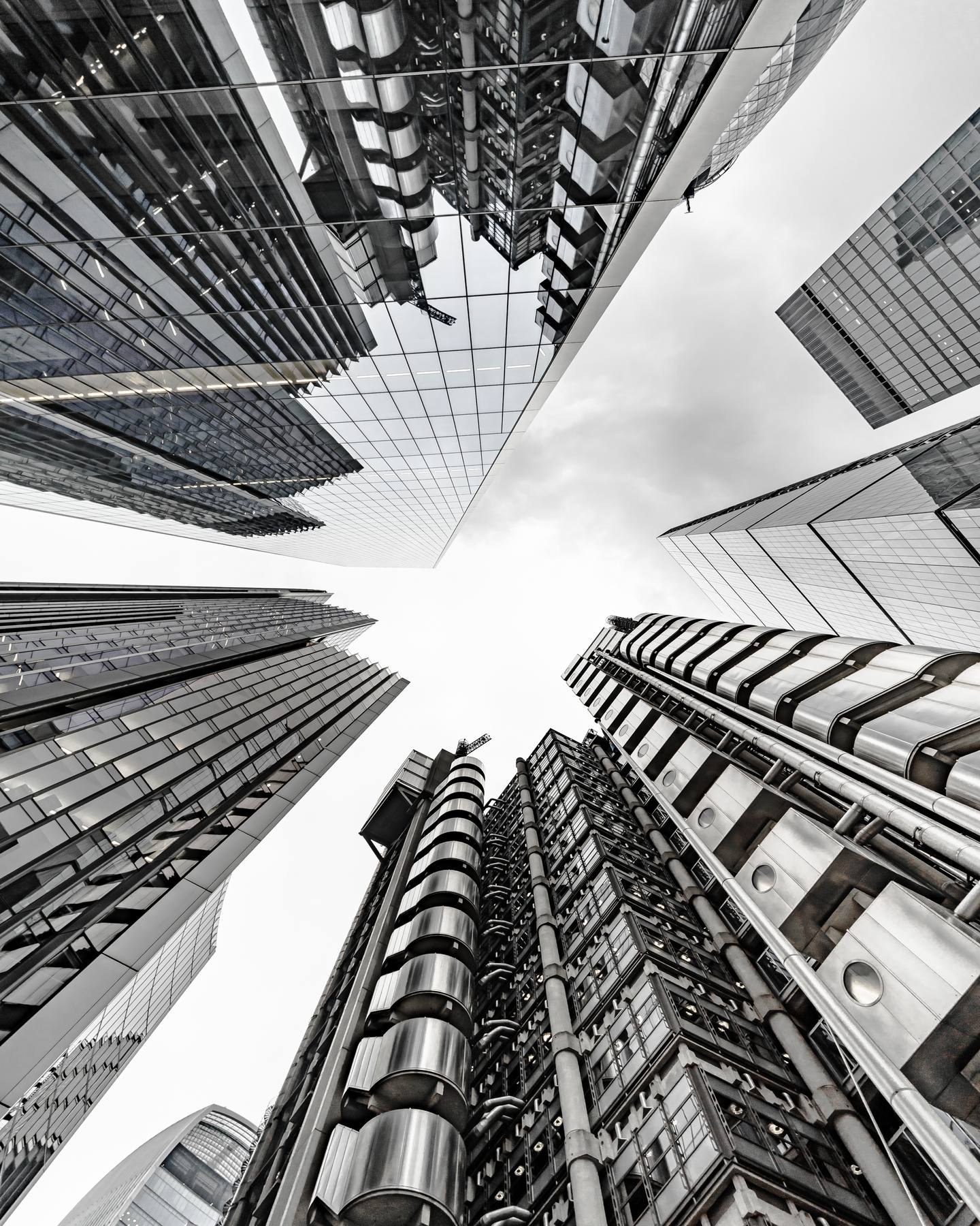 Looking straight up at a cluster of glass and steel office towers in a financial district